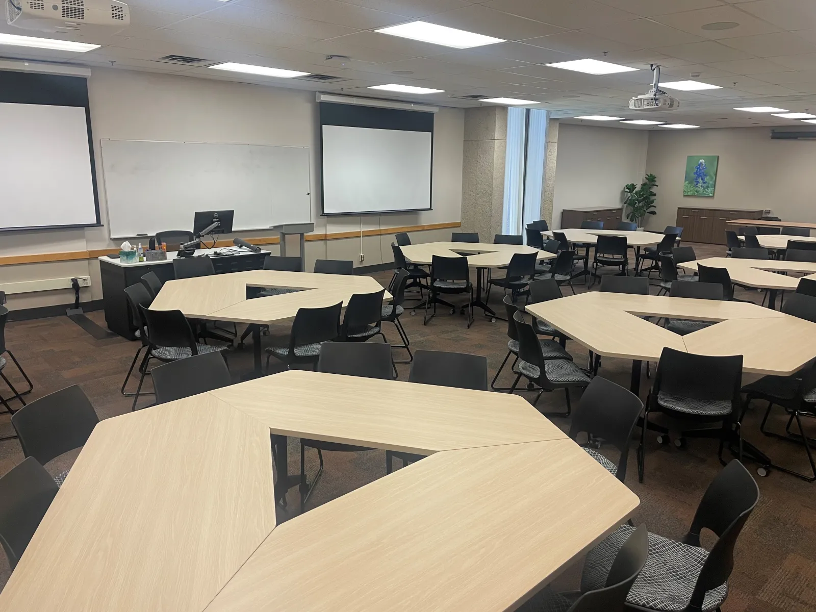 Large room with groups facing two projector screens.